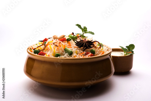 Indian Vegetable Pulav or Biryani made using Basmati Rice, served in a ceramic bowl. selective focus photo