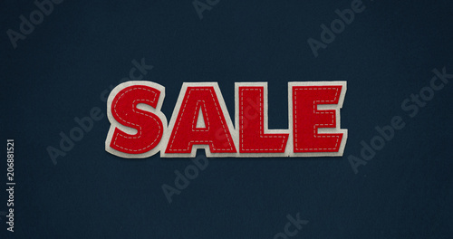 Sale. Red word on dark blue background with felt texture.