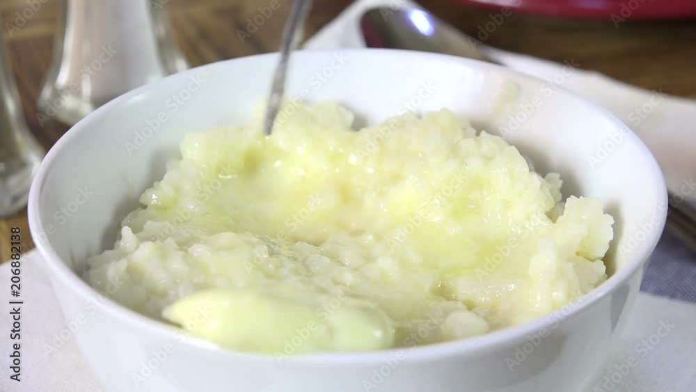 Melting butter into a bowl of mashed cauliflower Melting butter into a bowl of mashed cauliflower