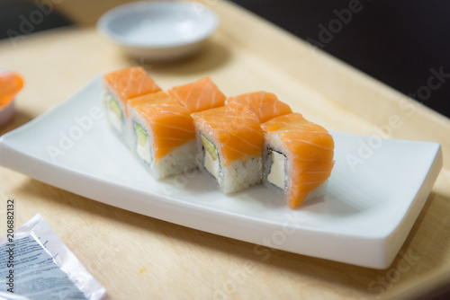 Portion of rolls with salmon on a white plate. Japanese food.