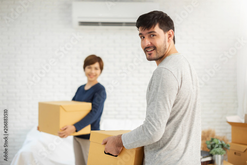Couple with cardboard boxes at new home.