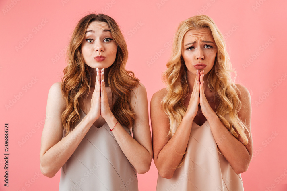 Two worried pretty women in pajamas praying with pray gestures Two worried pretty women in pajamas praying with pray gestures