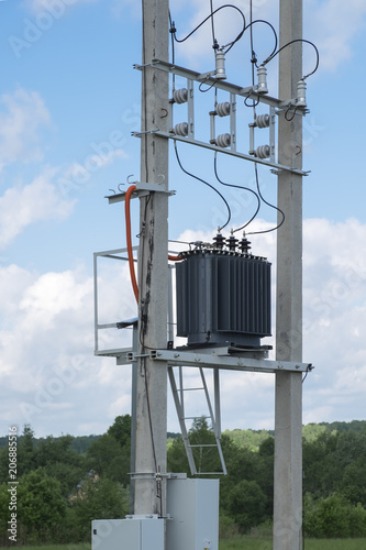 Canvas Print Electric transformer stands on concrete supports.