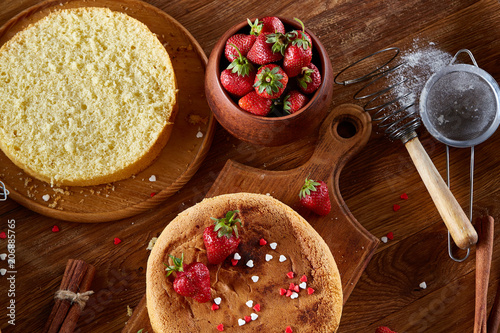 Delicious cake with fresh organic strawberries and kitchen utensils, top view, close-up, selctive focus. photo