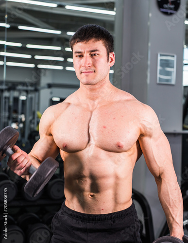 Muscular bodybuilder guy in gym