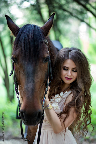 portrait of a beautiful girl in a smart dress with a horse close-up
