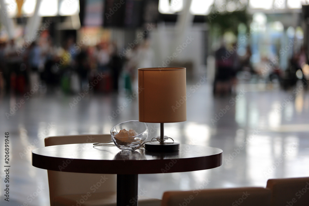 Stolik z lampką w hali portu lotniczego. - obrazy, fototapety, plakaty 