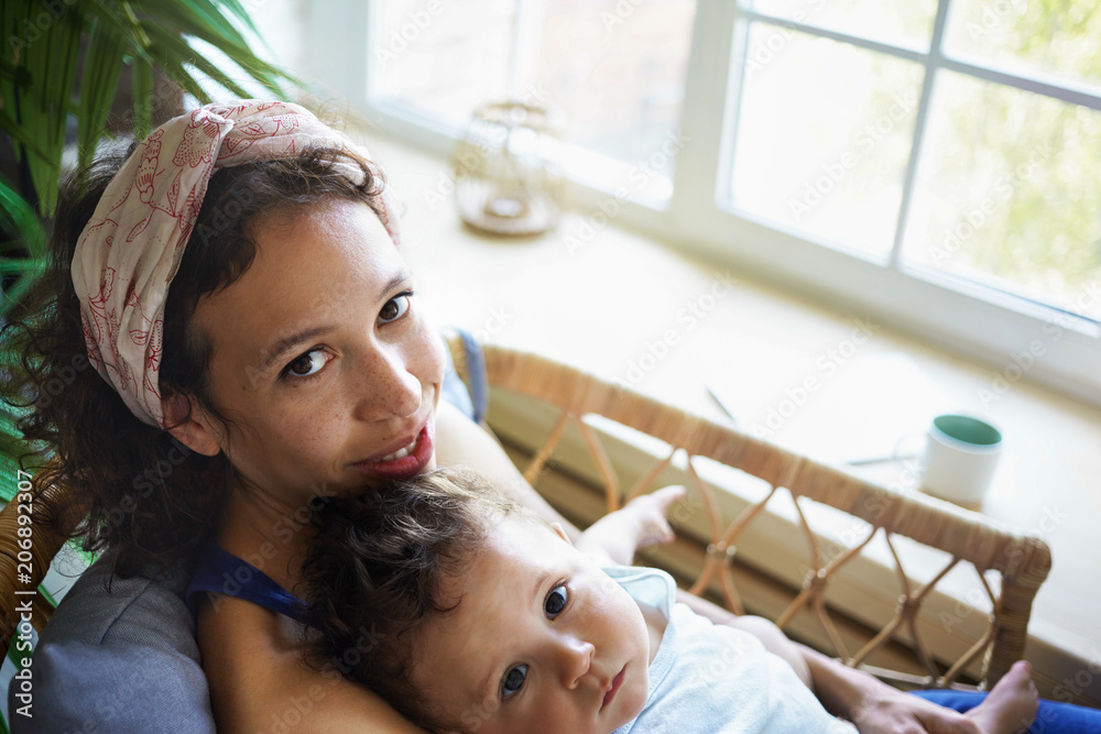 chubby young mom Top view of young Latin mom and infant son enjoying family bonding at home.  Positive dark