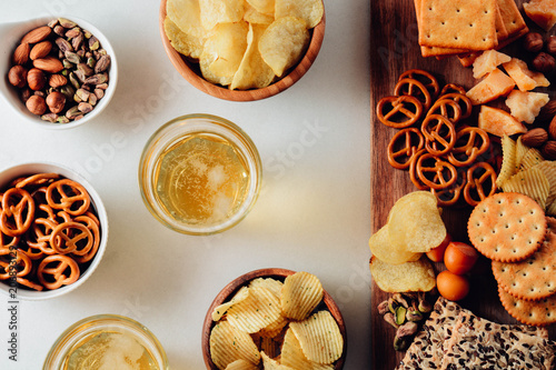 Lager beer and snacks on stone table. Nuts, chips. Top view with copyspace