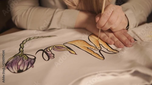 close up shot of a teenage hands, the lady decorates his clothes using fashionable and stylish manual labor, a woman uses a watercolor drawing photo