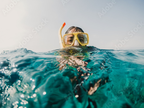 Lovely woman doing snorkeling at the gili islands in Indonesia. Wearing yellow glasses at the blue sea. Travel photography, lifestyle.