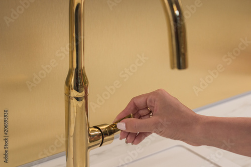 The girl opens the faucet for washing hands