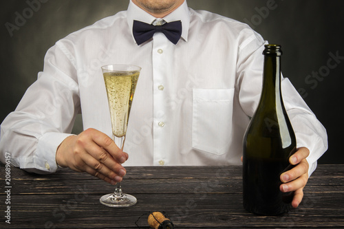 Cropped image of bartender pouring champagne into glass at bar counter photo