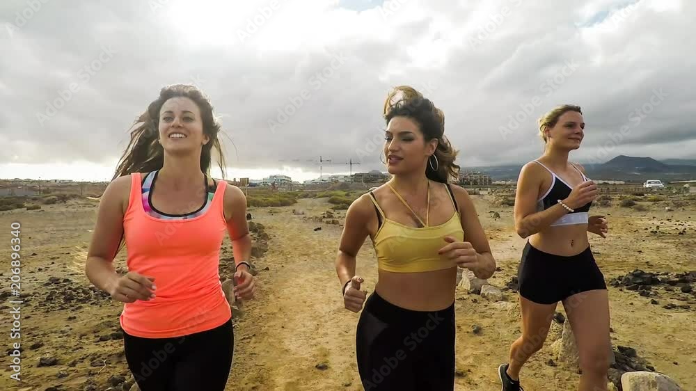 three beautiful young women run and do fitness outdoor. nice leisure activity all together in slow motion to represent healhy life and beauty body and faces. people outdoor enjoy run three beautiful young women run and do fitness outdoor. nice leisure activity all together in slow motion to represent healhy life and beauty body and faces. people outdoor enjoy run
