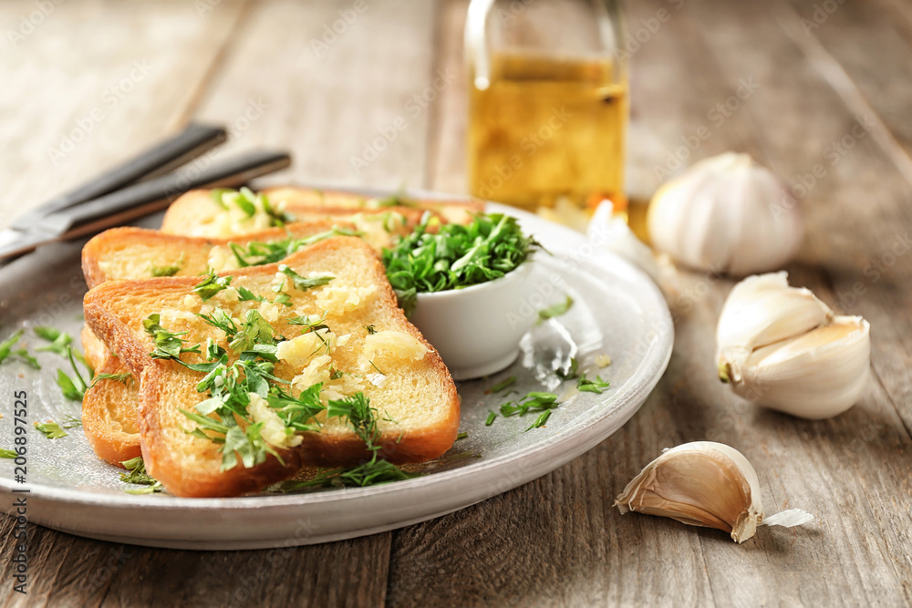 Plate with delicious homemade garlic bread on table Plate with delicious homemade garlic bread on table