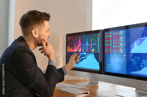 Male broker working in offi...