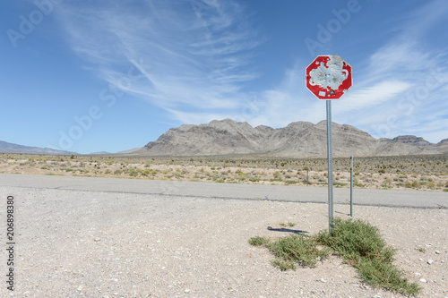 Panneau stop abimé par les tirs de fusil dans le désert du Nevada