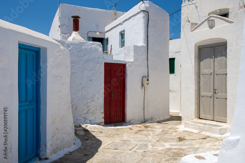 Amorgos,Greece-August 4 ,2017.Traditional wooden multi colored doors and a white stone walls in Amorgos