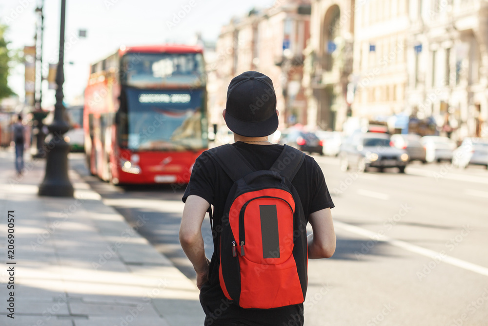 People, travel, tourism and education concept - stylish young man with backpack over london city bus on street background People, travel, tourism and education concept - stylish young man with backpack over london city bus on street background