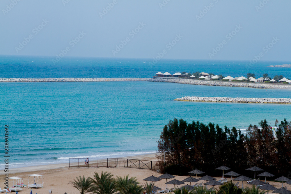 Beautiful blue sea and beach resort huts from al hamra beach view