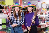 Comically dressed happy female friends in festival outfits shop