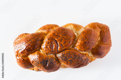 braided bread sprinkled with poppy seeds, isolated on white. copy space photo