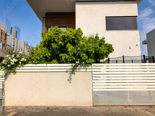 Private modern houses with big white fence on the streets in Rishon LeZion, Israel photo