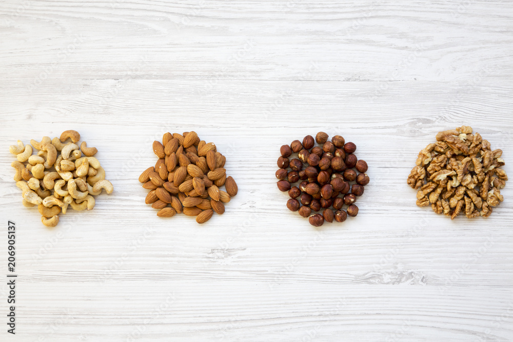 Assortment of nuts on white wooden background. Cashew, hazelnuts, walnuts, almonds. Top view. Assortment of nuts on white wooden background. Cashew, hazelnuts, walnuts, almonds. Top view.