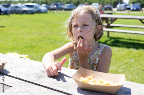 Girl sitting at bench eating chips