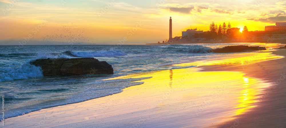 Beach and view of Maspalomas lighthouse at sunset. Gran Canaria, Spain