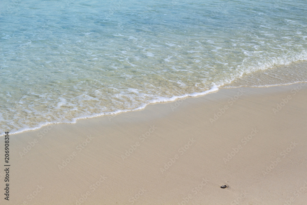 Turquoise sea water on sand beach photo background. Wave on white beach sand. Tropical seashore idyllic view.