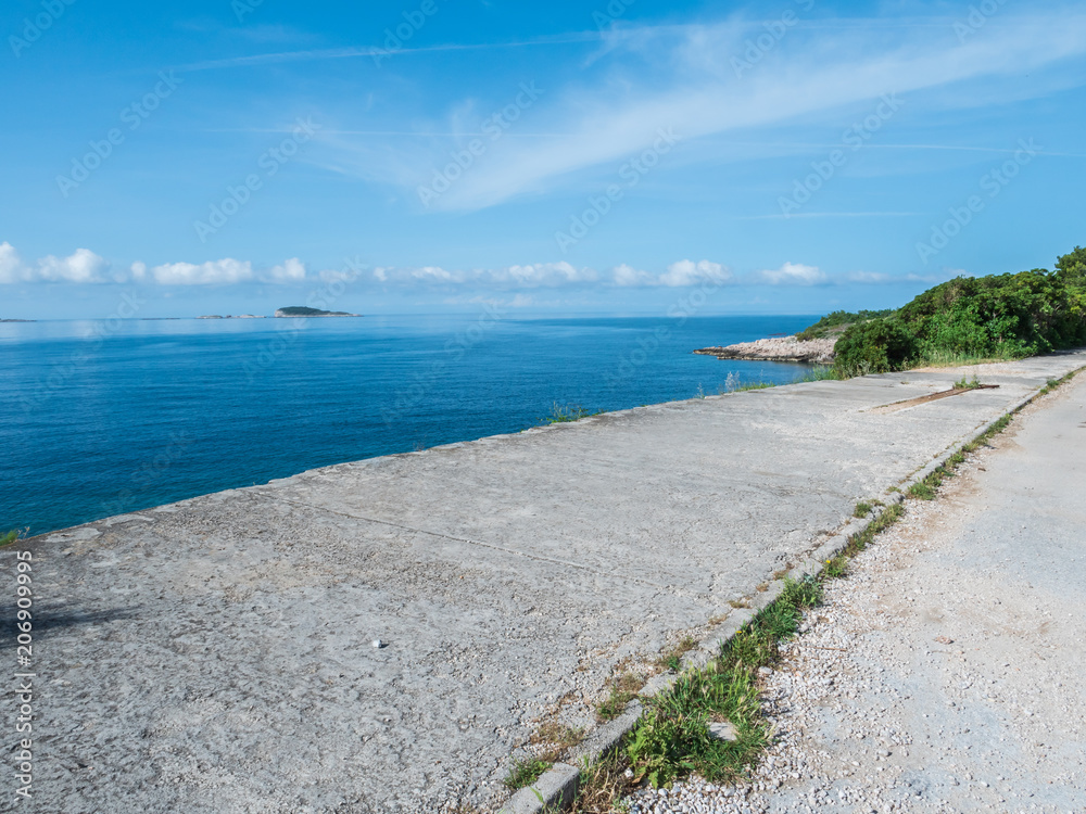 concrete road along coastline with sea in the background