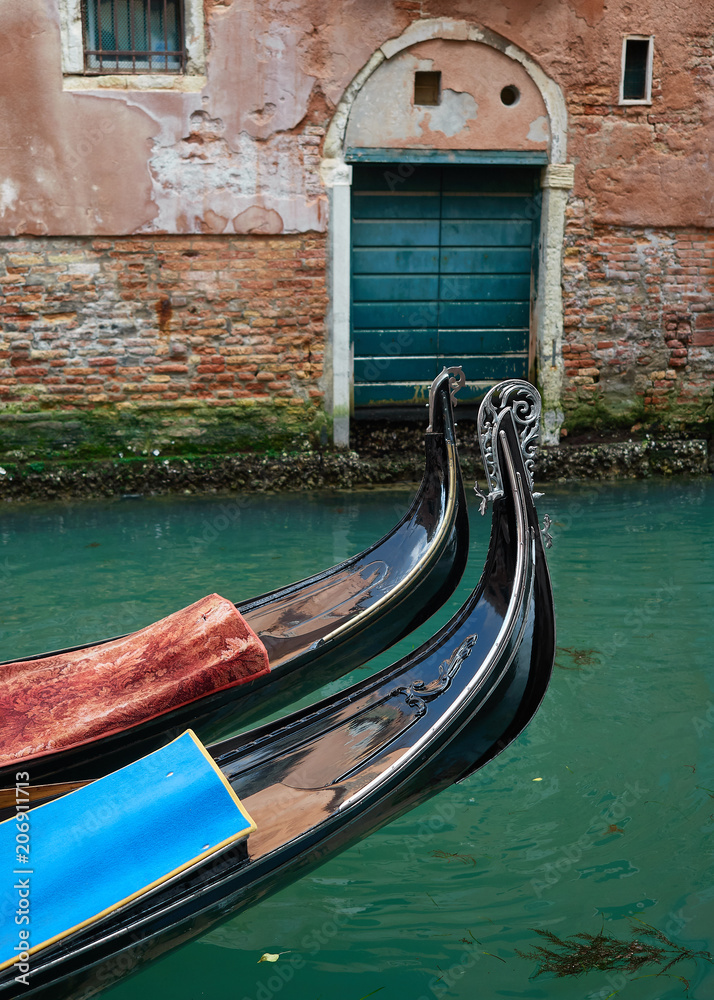 Proas de Dos Góndolas Tradicionales Atracadas en un Canal de la Ciudad de Venecia, Italia