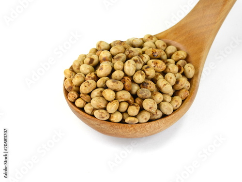 Roasted soybeans (soy nuts) in a wooden spoon isolated on white background.