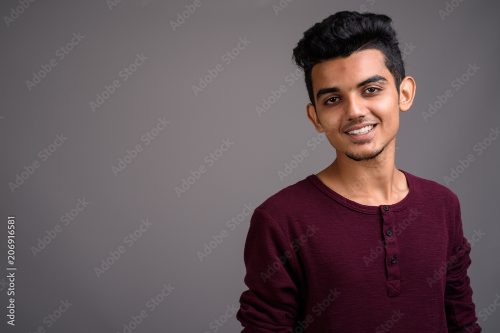 Young Indian man against gray background Young Indian man against gray background