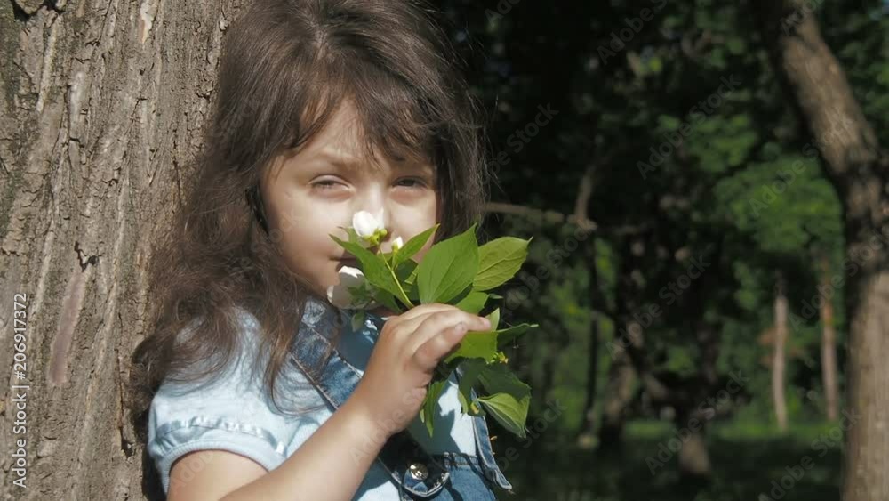 Child with flowers in the park. A little girl is sniffing flowers. Child with flowers in the park. A little girl is sniffing flowers.