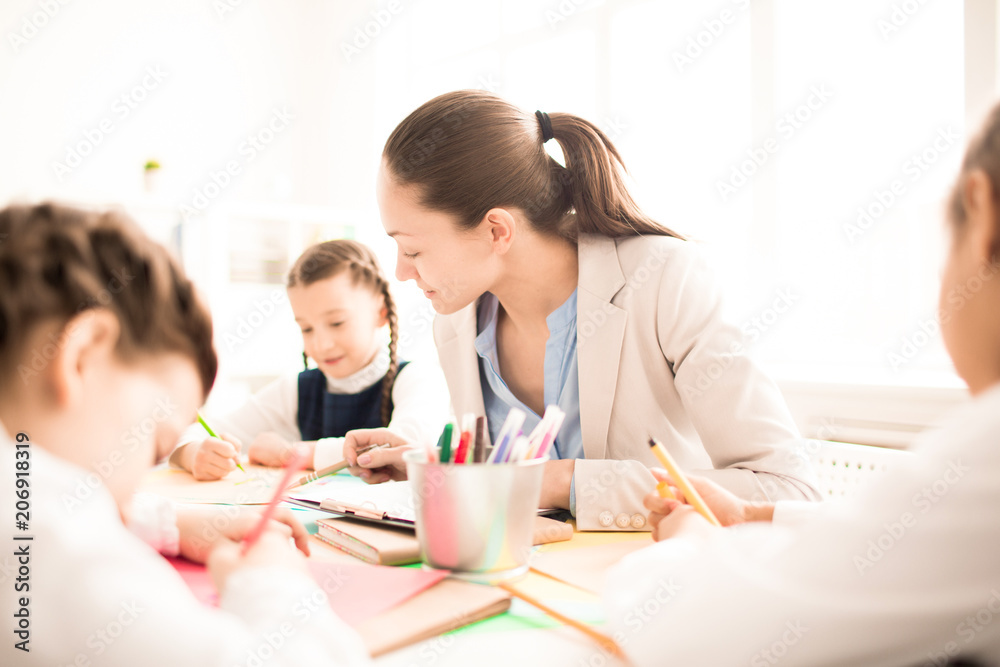 Small students with teacher painting in art school class Small students with teacher painting in art school class