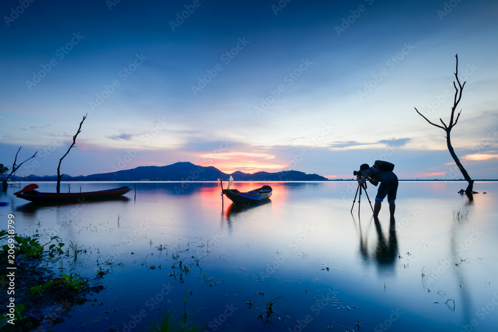 Professional photographer taking photo at sunset beside the river