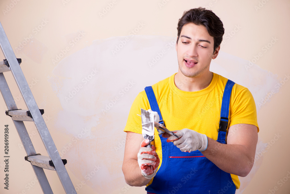 Young contractor employee applying plaster on wall