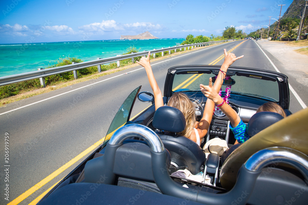 Road trip travel - girls driving car in freedom. Happy young girls cheering in  convertible car on summer Hawaii vacations. Photos | Adobe Stock