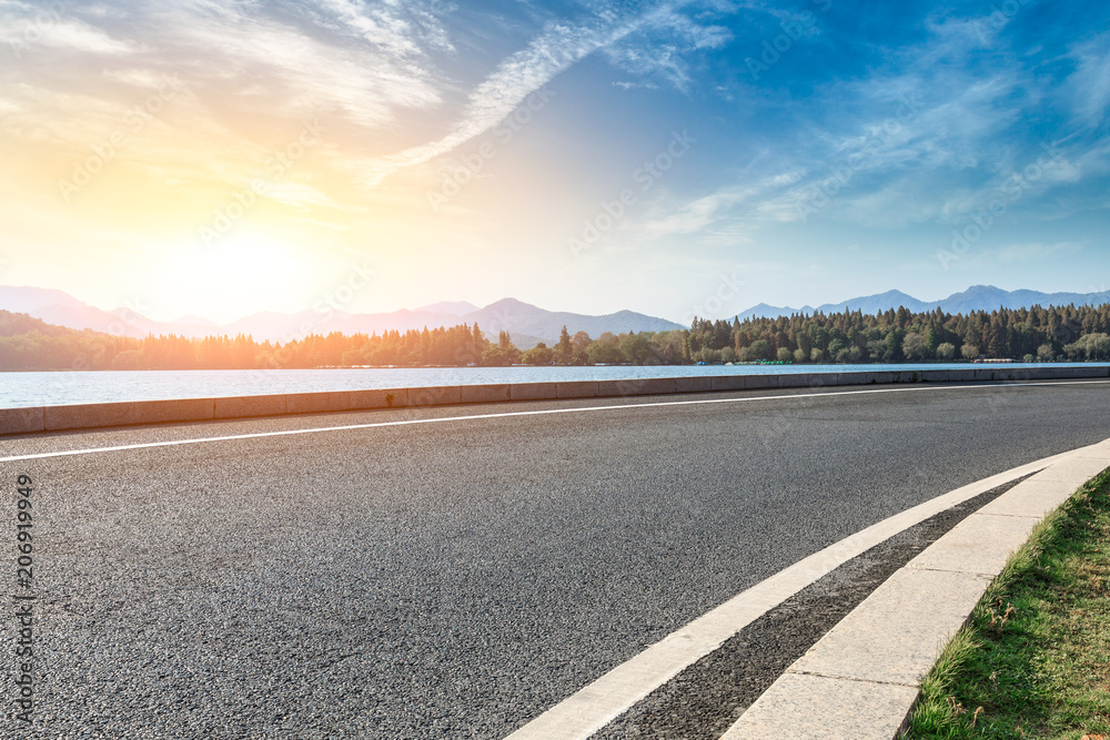 Fototapeta premium Asphalt road and hills with sky clouds landscape at sunset
