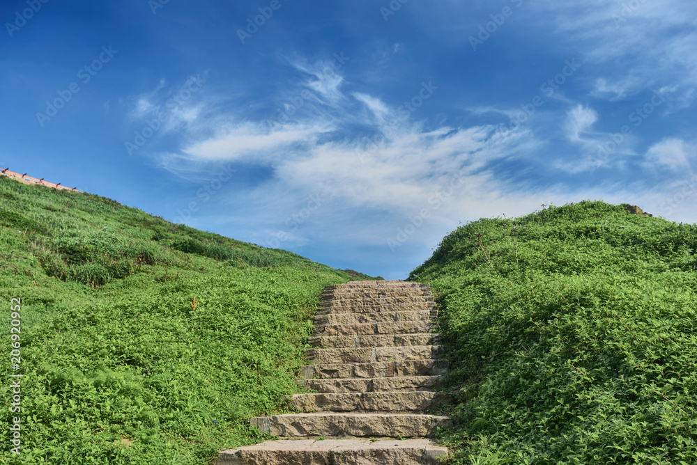 Stone steps on the grass under blue sky in Matsu, Taiwan Stone steps on the grass under blue sky in Matsu, Taiwan