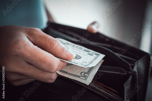 woman hand holding American currency of five dollar bills, spending and shopping for human desire, world of business and using money.