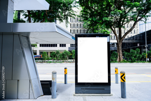  billboard on bus stop with empty advertising banner on sunlit street.