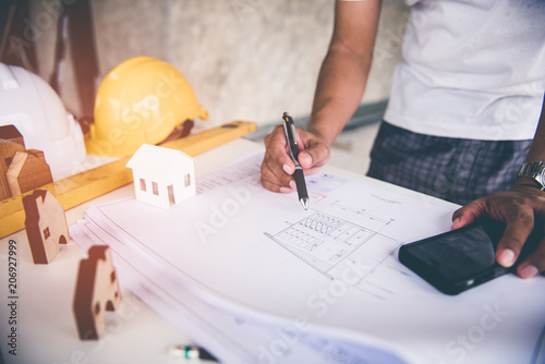 architect man working with blueprints,engineer inspection in workplace for architectural plan,sketching a construction project ,selective focus.