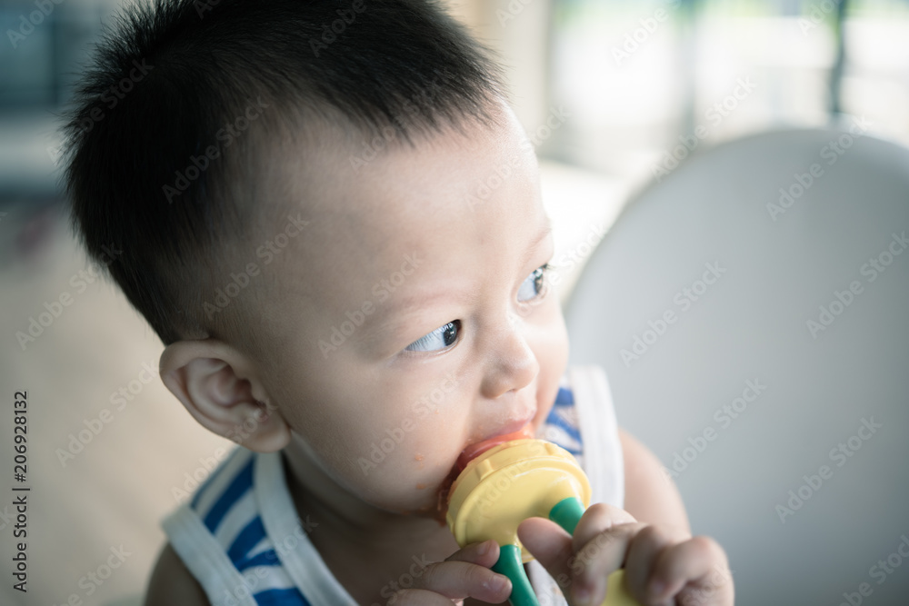 Asian cute baby boy are eating fruit from the accessory. Asian cute baby boy are eating fruit from the accessory.