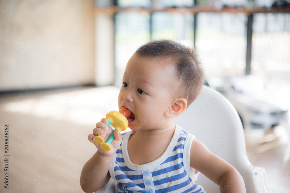 Asian cute baby boy are eating fruit from the accessory. Asian cute baby boy are eating fruit from the accessory.