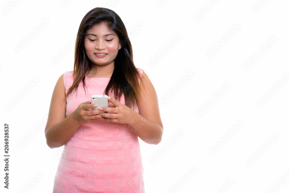 Studio shot of young happy fat Persian teenage girl smiling whil