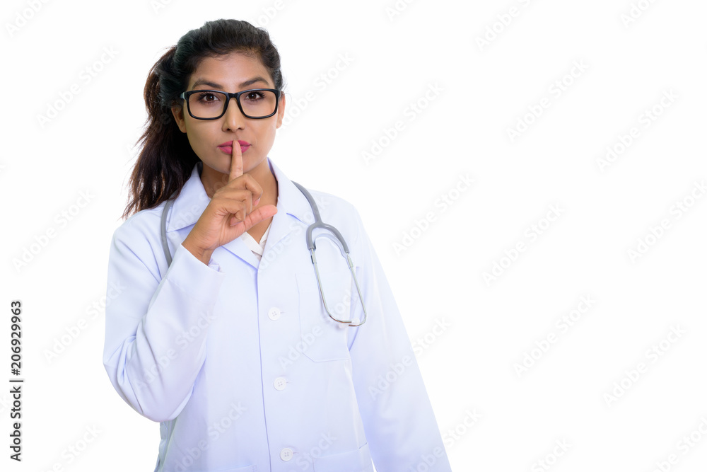 Studio shot of young beautiful Persian woman doctor with finger 