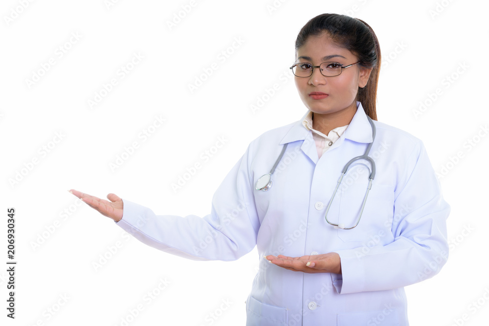 Studio shot of young fat Persian woman doctor showing something Studio shot of young fat Persian woman doctor showing something